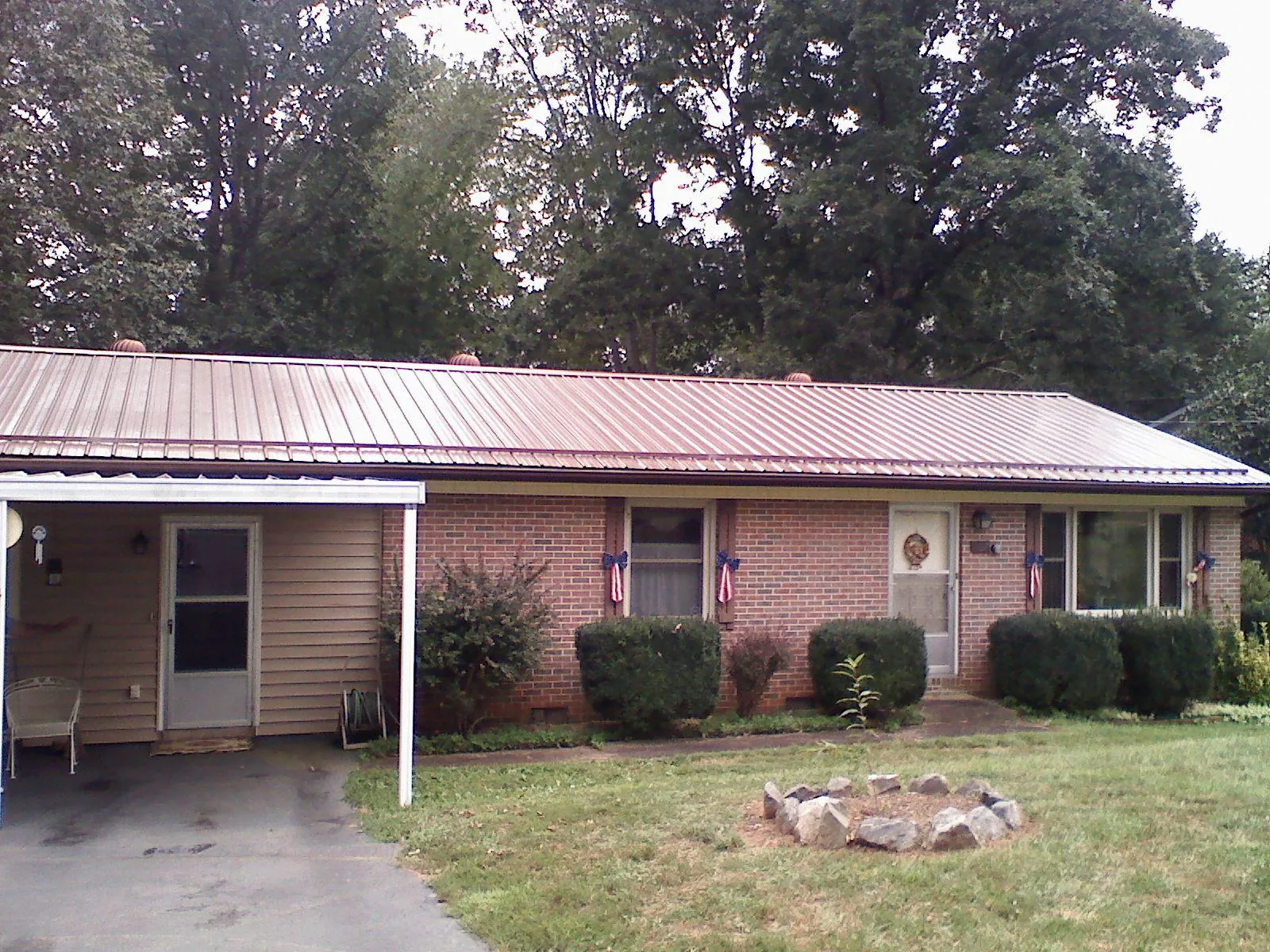 Bronze metal roof and carport on a brick ranch home — Roof Repair work by our crew in Centerville
